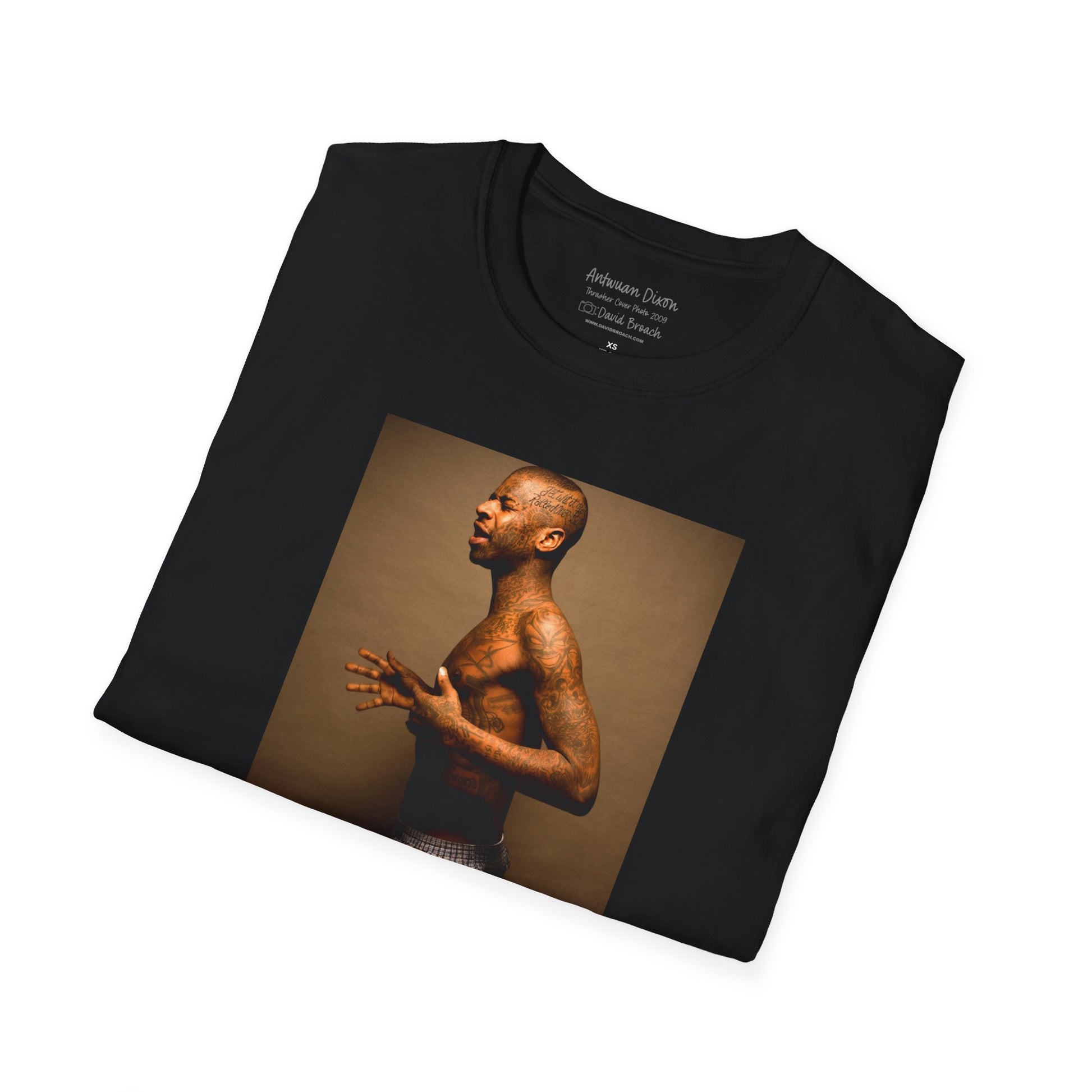 A neatly folded black crew neck short-sleeve T-shirt featuring a high-quality printed portrait of pro skater Antwuan Dixon, as seen on the cover of Thrasher Magazine. Captured by renowned skate photographer David Broach, this iconic design showcases Dixon’s unmistakable style and presence. Perfect for skateboarding enthusiasts, streetwear fans, and collectors looking for a statement piece.