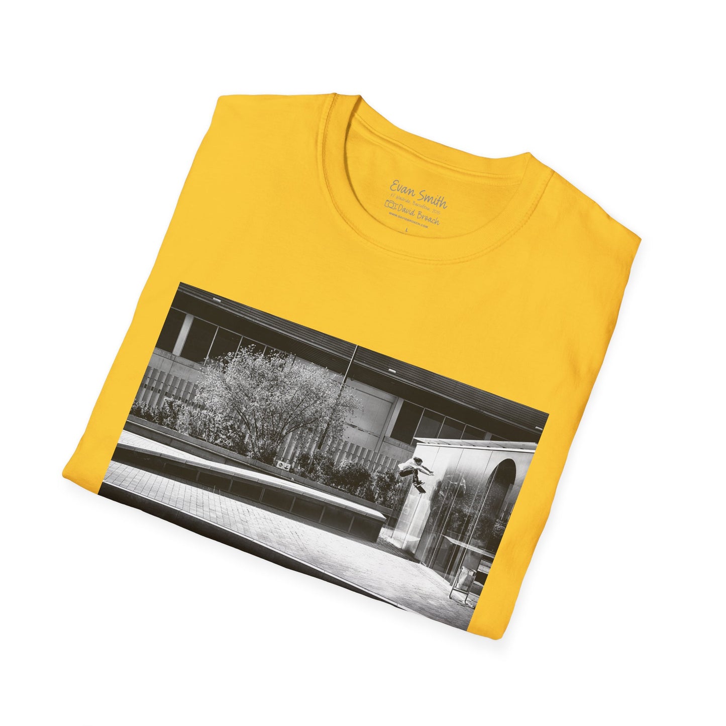 Yellow Shirt folded with print of Black and white photo of Evan Smith doing a kick flip wallride in Barcelona Spain. Off bump onto wall.