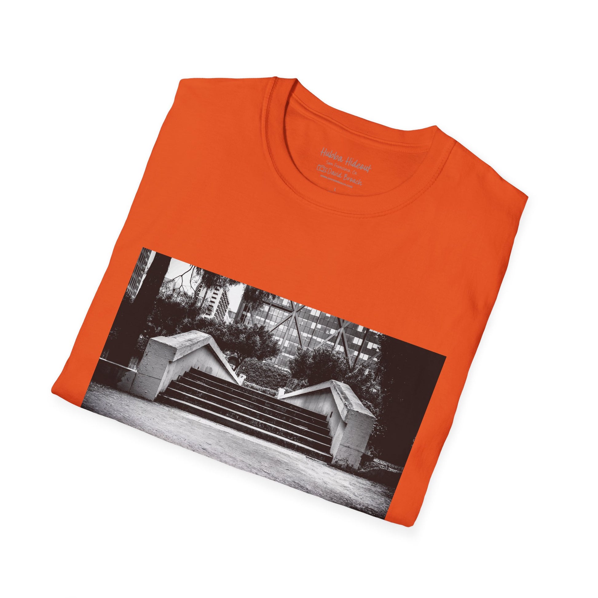 A neatly folded T-shirt featuring a black-and-white photo of the iconic Hubba Hideout skate spot printed on the front. The bold contrast of the monochrome image against the fabric highlights the design, making it a standout piece for skateboarding enthusiasts and streetwear fans.