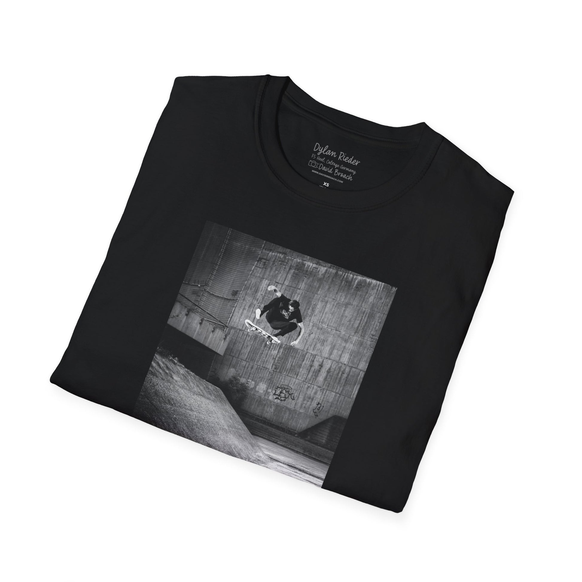 Neatly Folded Black Short-sleeve crew neck T-shirt featuring a printed photo of Dylan Rieder executing a flawless frontside heelflip off a bump in Germany. Captured by photographer David Broach and featured on the Thrasher tribute cover, this design honors Dylan’s timeless style and effortless power, making it a must-have for skateboarding enthusiasts and collectors.