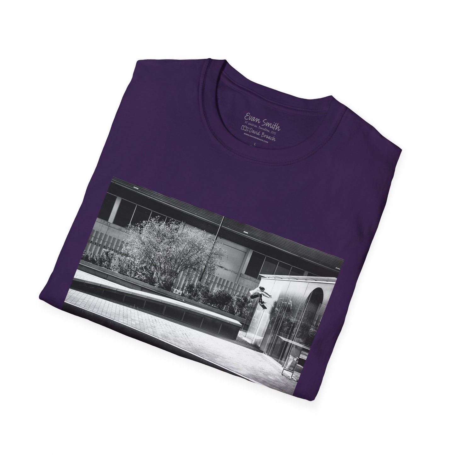 Purple Shirt folded with print of Black and white photo of Evan Smith doing a kick flip wallride in Barcelona Spain. Off bump onto wall.