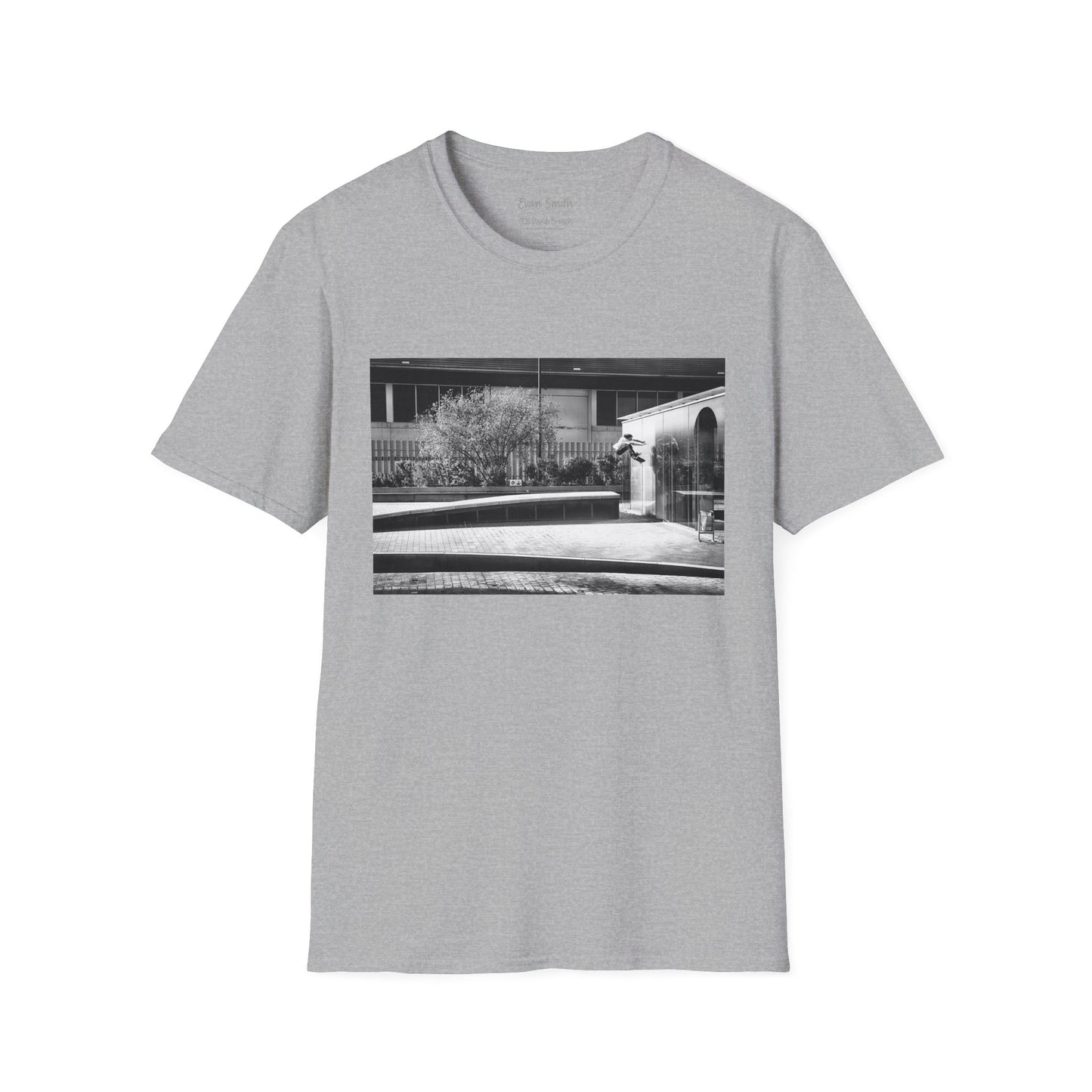 Grey Shirt with print of Black and white photo of Evan Smith doing a kick flip wallride in Barcelona Spain. Off bump onto wall.
