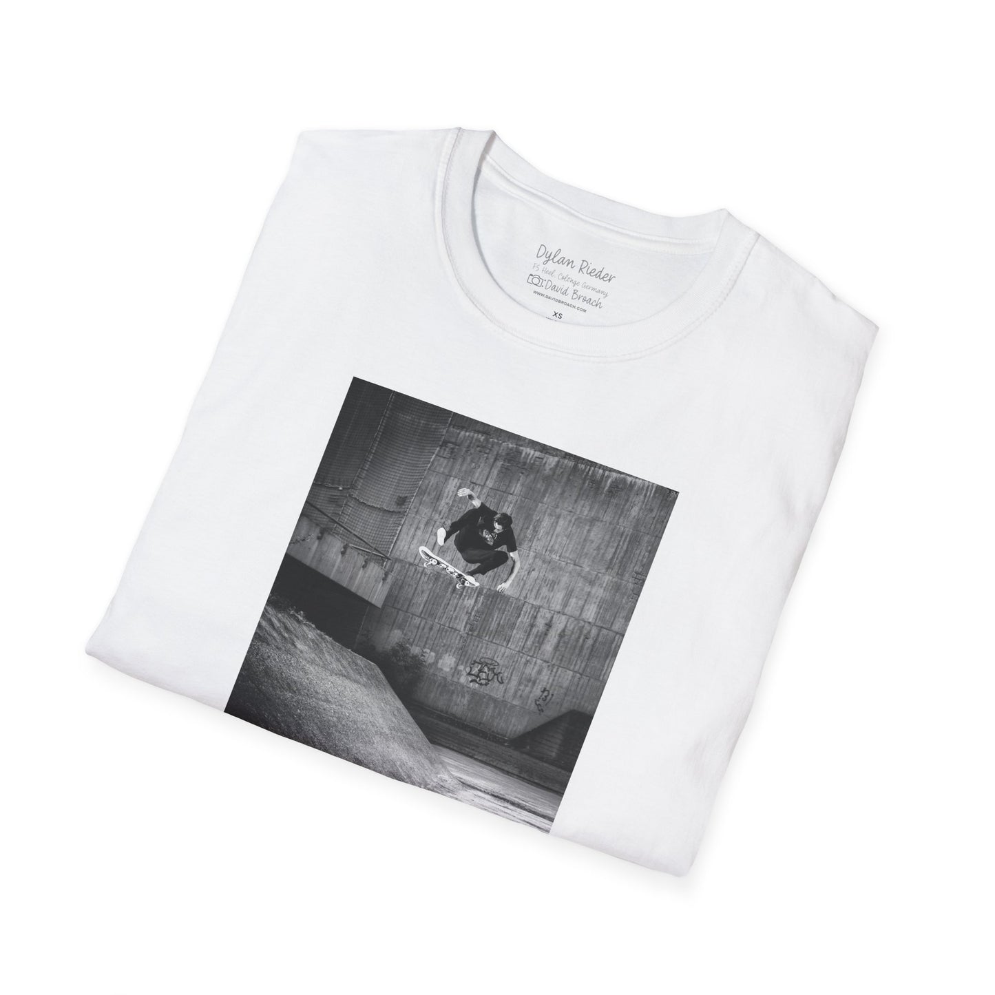 Neatly Folded white Short-sleeve crew neck T-shirt featuring a printed photo of Dylan Rieder executing a flawless frontside heelflip off a bump in Germany. Captured by photographer David Broach and featured on the Thrasher tribute cover, this design honors Dylan’s timeless style and effortless power, making it a must-have for skateboarding enthusiasts and collectors.