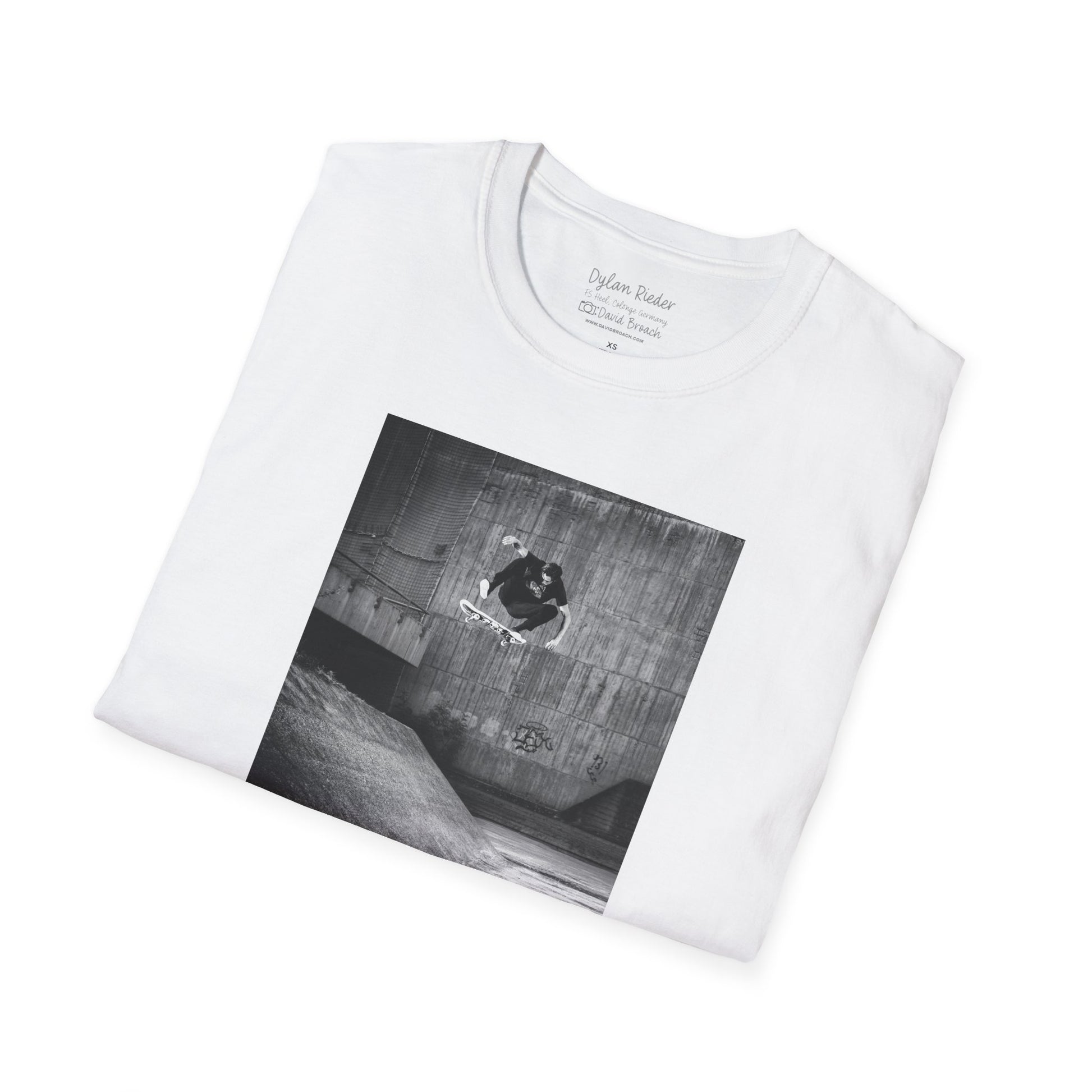 Neatly Folded white Short-sleeve crew neck T-shirt featuring a printed photo of Dylan Rieder executing a flawless frontside heelflip off a bump in Germany. Captured by photographer David Broach and featured on the Thrasher tribute cover, this design honors Dylan’s timeless style and effortless power, making it a must-have for skateboarding enthusiasts and collectors.
