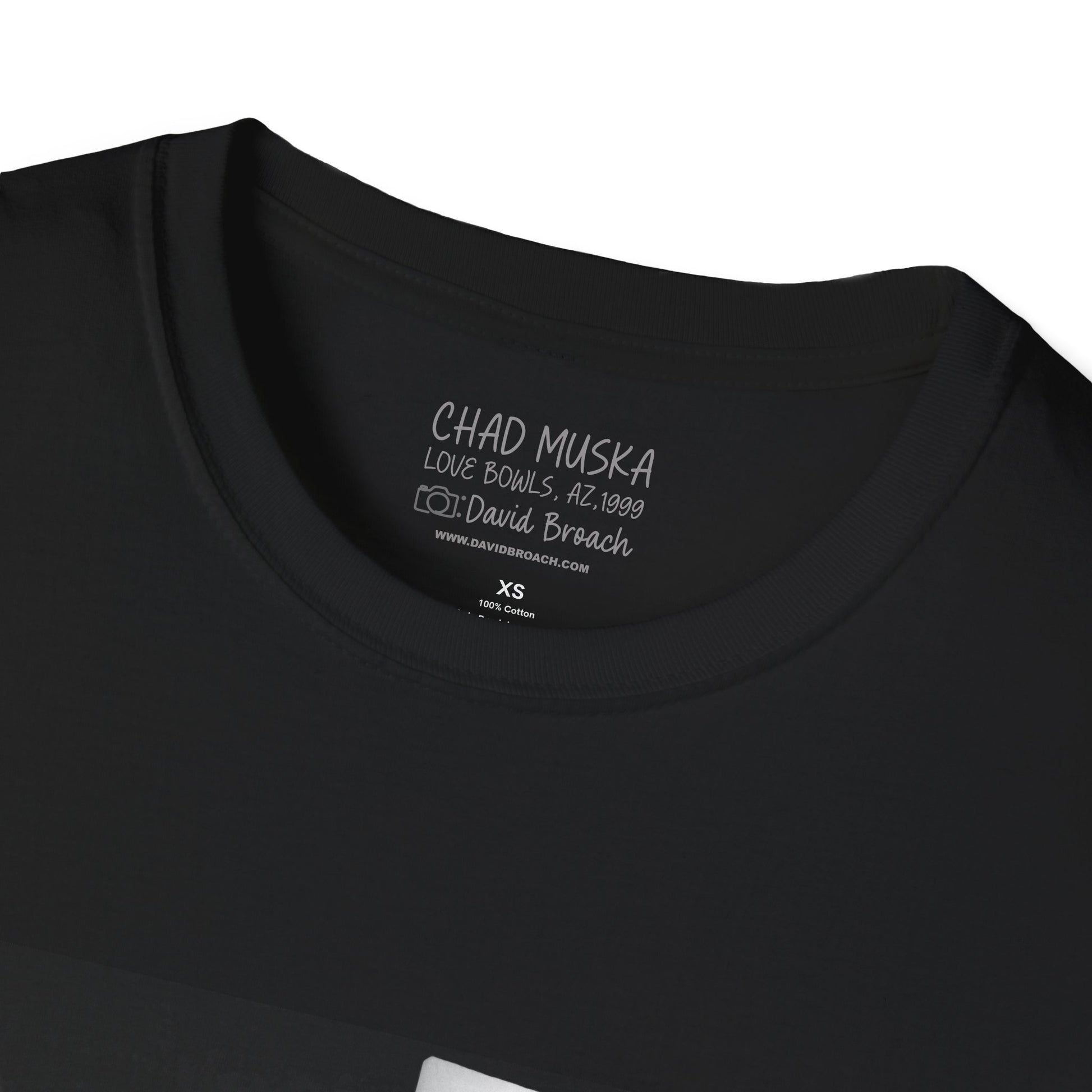 Close-up of the crew neck collar of a black short-sleeve T-shirt featuring 'Chad Muska' and 'Photo by David Broach' printed on the inside. A subtle yet distinctive detail that adds authenticity to the design, making it a must-have for skateboarding enthusiasts and collectors."