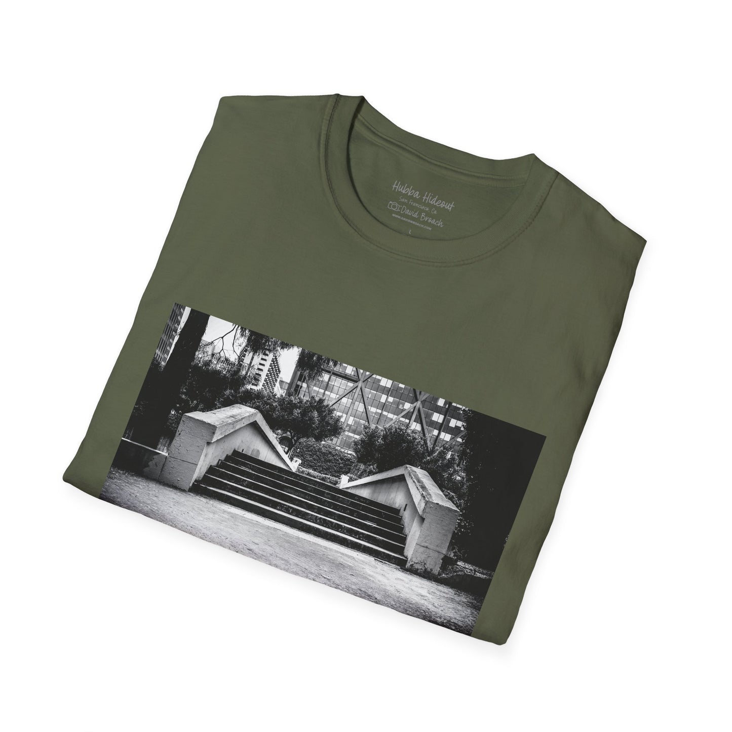 A neatly folded green  crew neck short-sleeve T-shirt featuring a printed photo of the iconic Hubba Hideout skate spot on the front. Captured by photographer David Broach, the detailed design highlights the legendary location, making it a must-have for skateboarding enthusiasts and streetwear fans.