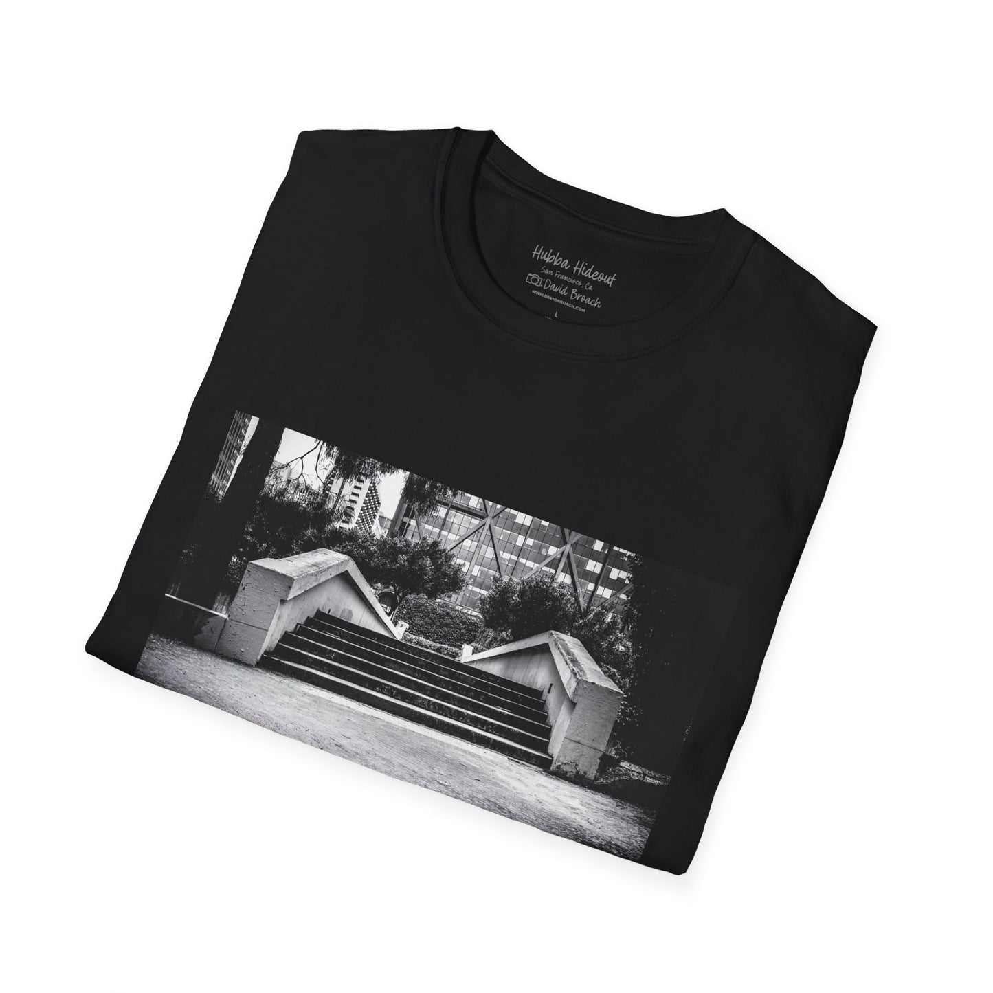 A neatly folded T-shirt featuring a black-and-white photo of the iconic Hubba Hideout skate spot printed on the front. The bold contrast of the monochrome image against the fabric highlights the design, making it a standout piece for skateboarding enthusiasts and streetwear fans.