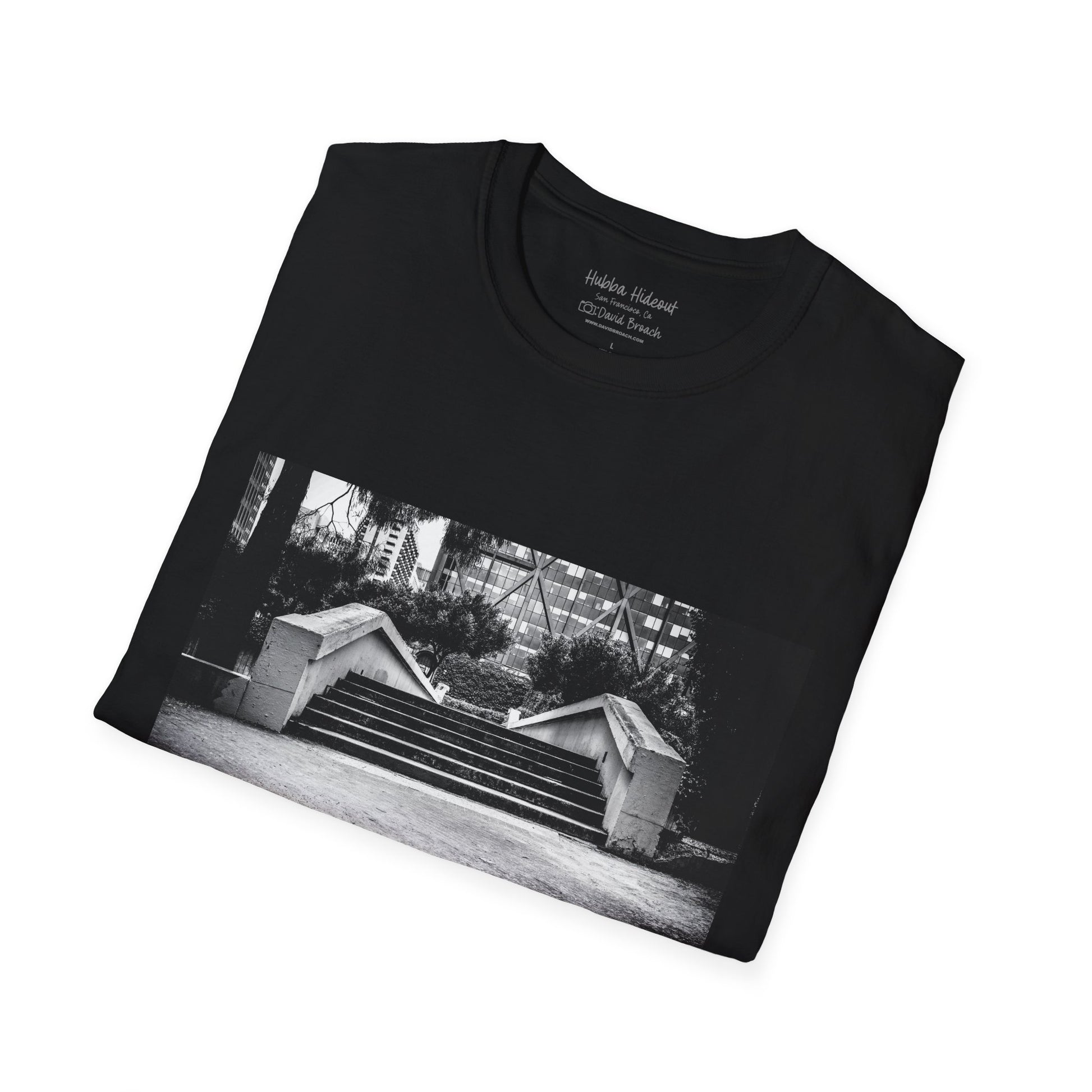 A neatly folded T-shirt featuring a black-and-white photo of the iconic Hubba Hideout skate spot printed on the front. The bold contrast of the monochrome image against the fabric highlights the design, making it a standout piece for skateboarding enthusiasts and streetwear fans.
