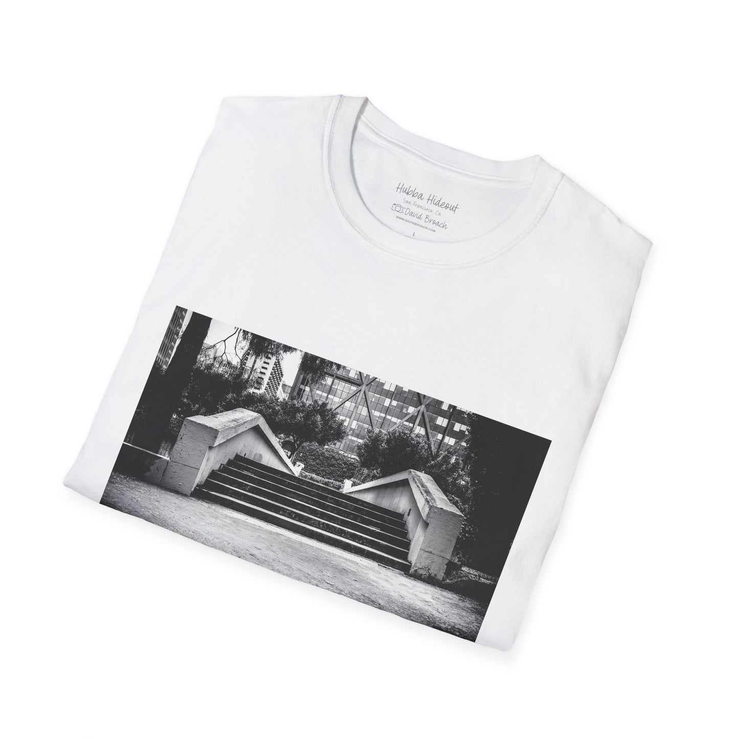A neatly folded T-shirt featuring a black-and-white photo of the iconic Hubba Hideout skate spot printed on the front. The bold contrast of the monochrome image against the fabric highlights the design, making it a standout piece for skateboarding enthusiasts and streetwear fans.