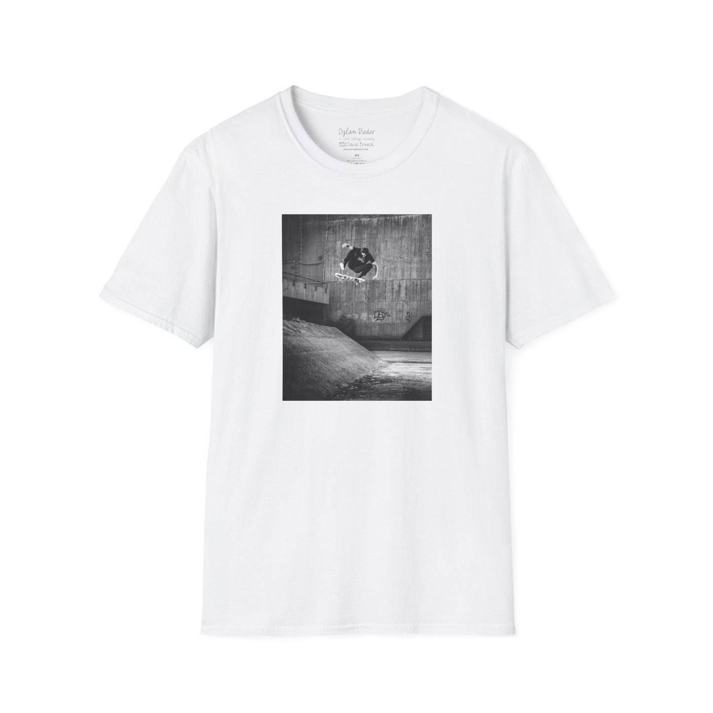 White Short-sleeve crew neck T-shirt featuring a printed photo of Dylan Rieder executing a flawless frontside heelflip off a bump in Germany. Captured by photographer David Broach and featured on the Thrasher tribute cover, this design honors Dylan’s timeless style and effortless power, making it a must-have for skateboarding enthusiasts and collectors.