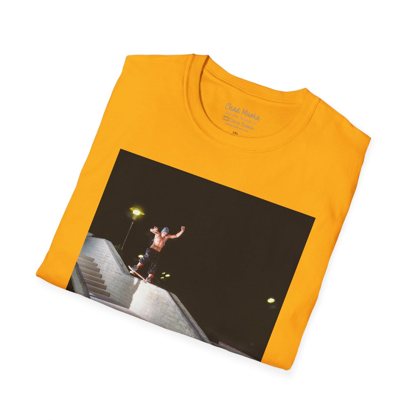 A neatly folded yellow crew neck short-sleeve T-shirt featuring a printed photo of A high-quality print featuring an iconic shot of Chad Muska in 1999 executing a smooth nose slide down the triple-kink Hubba rail at The Wedge in Phoenix, Arizona. Captured by photographer David Broach, this image showcases Muska’s signature style and fearless approach, making it a must-have for skateboarding enthusiasts and collectors."