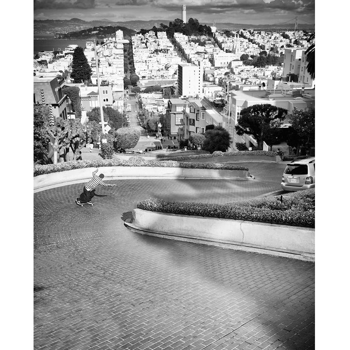 A high-quality archival matte paper print featuring a black-and-white photo of Frank Gerwer riding down the iconic Lombard Street in San Francisco. Captured by renowned skate photographer David Broach, this striking image blends raw energy with the city’s legendary landscape. Printed on premium archival matte paper for exceptional detail and longevity, making it a must-have for skateboarding enthusiasts, collectors, and art lovers alike.