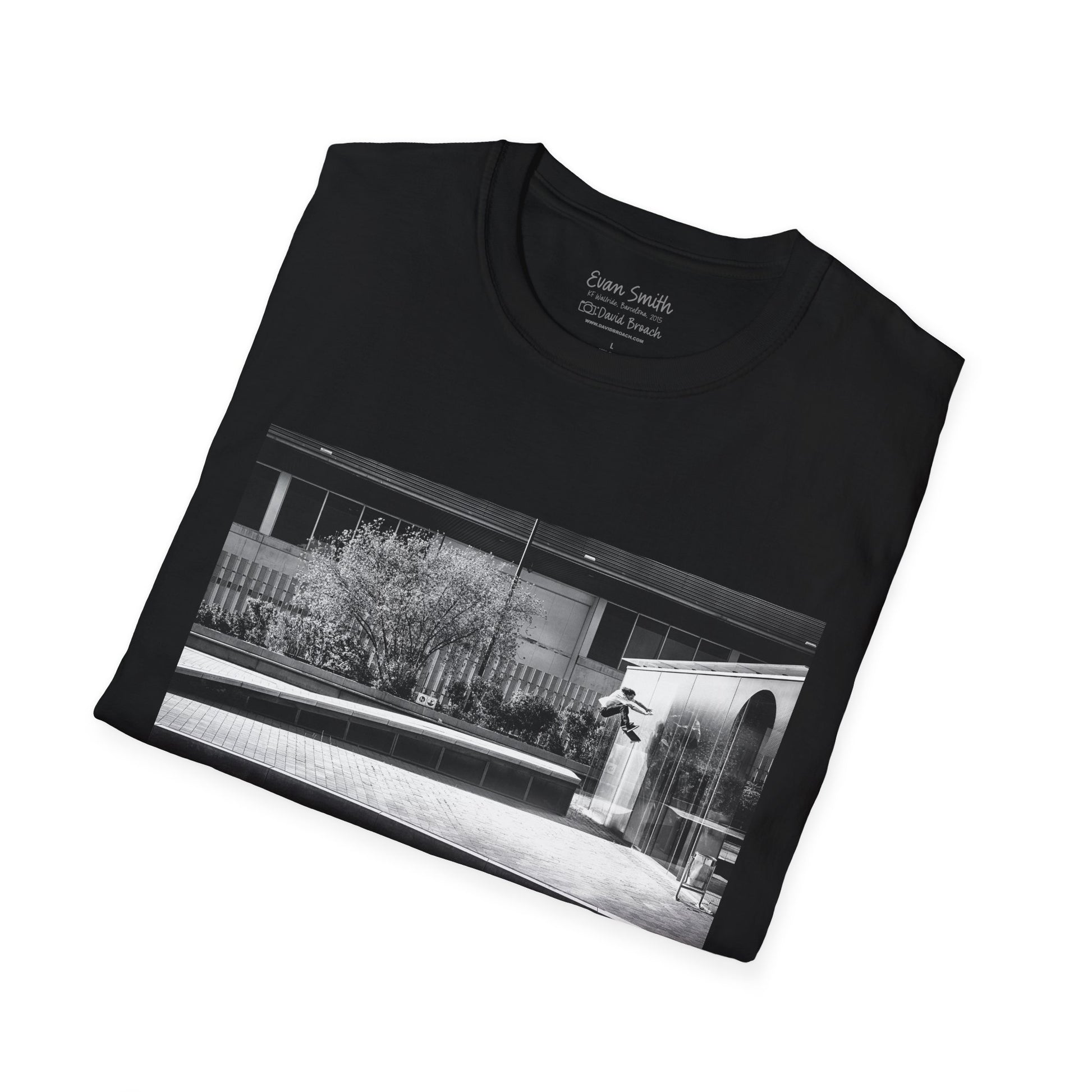 Black Shirt folded with print of Black and white photo of Evan Smith doing a kick flip wallride in Barcelona Spain. Off bump onto wall.