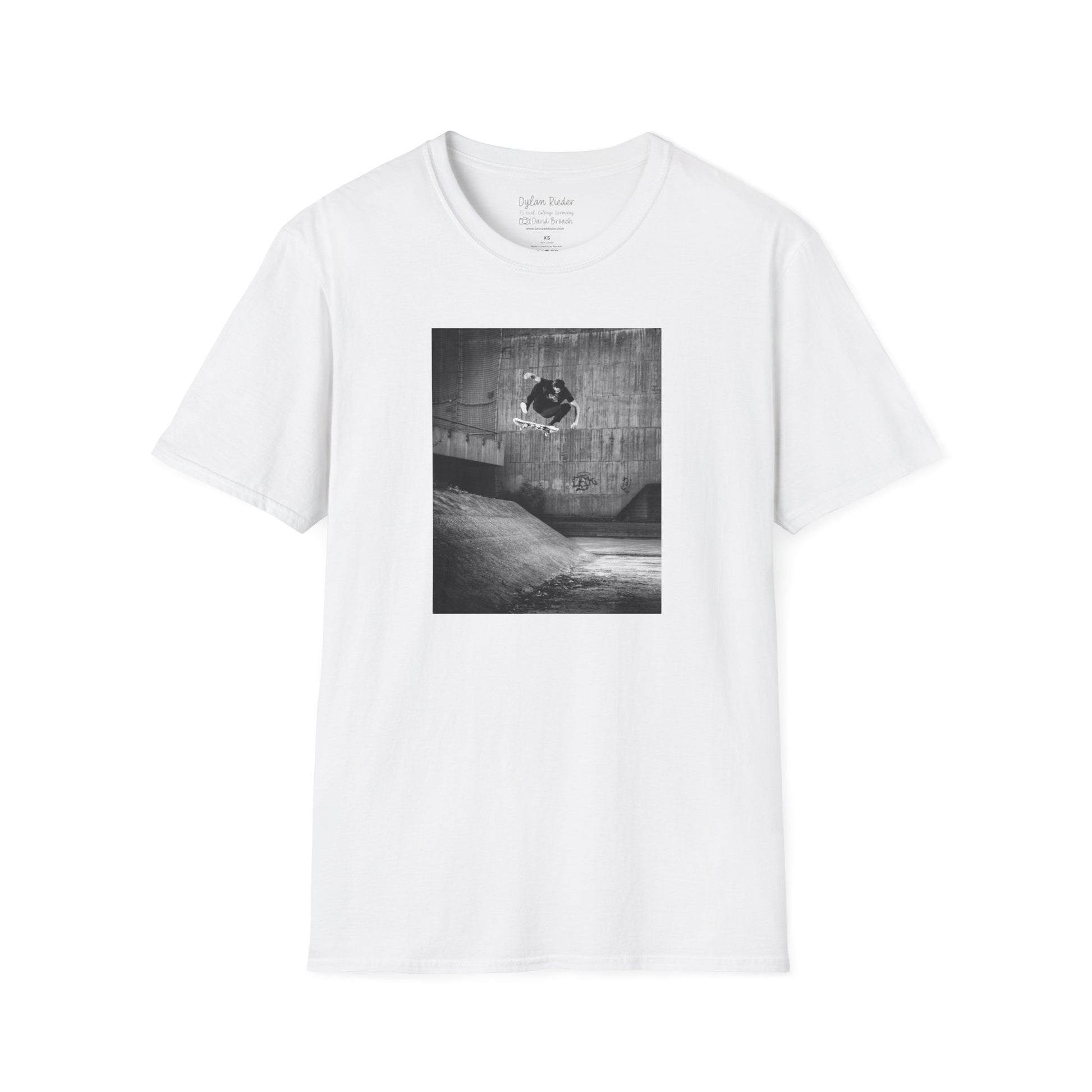 White Short-sleeve crew neck T-shirt featuring a printed photo of Dylan Rieder executing a flawless frontside heelflip off a bump in Germany. Captured by photographer David Broach and featured on the Thrasher tribute cover, this design honors Dylan’s timeless style and effortless power, making it a must-have for skateboarding enthusiasts and collectors.